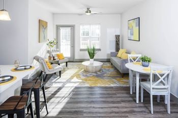 A living room with a dining room table and chairs